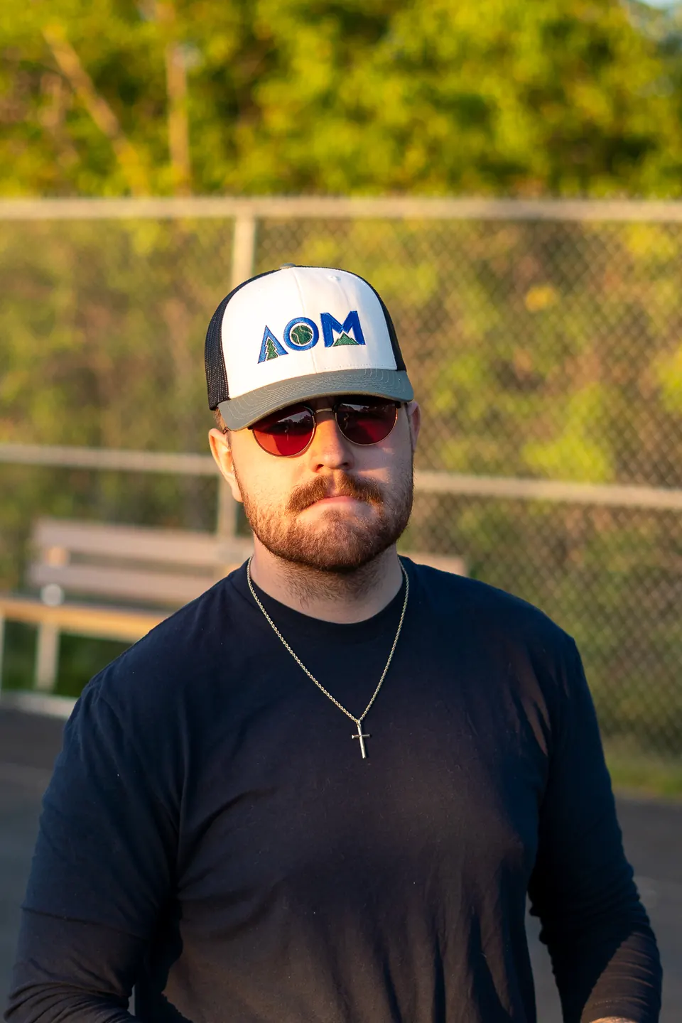 Portrait of a player in an AllOutMaine trucker hat on a basketball court