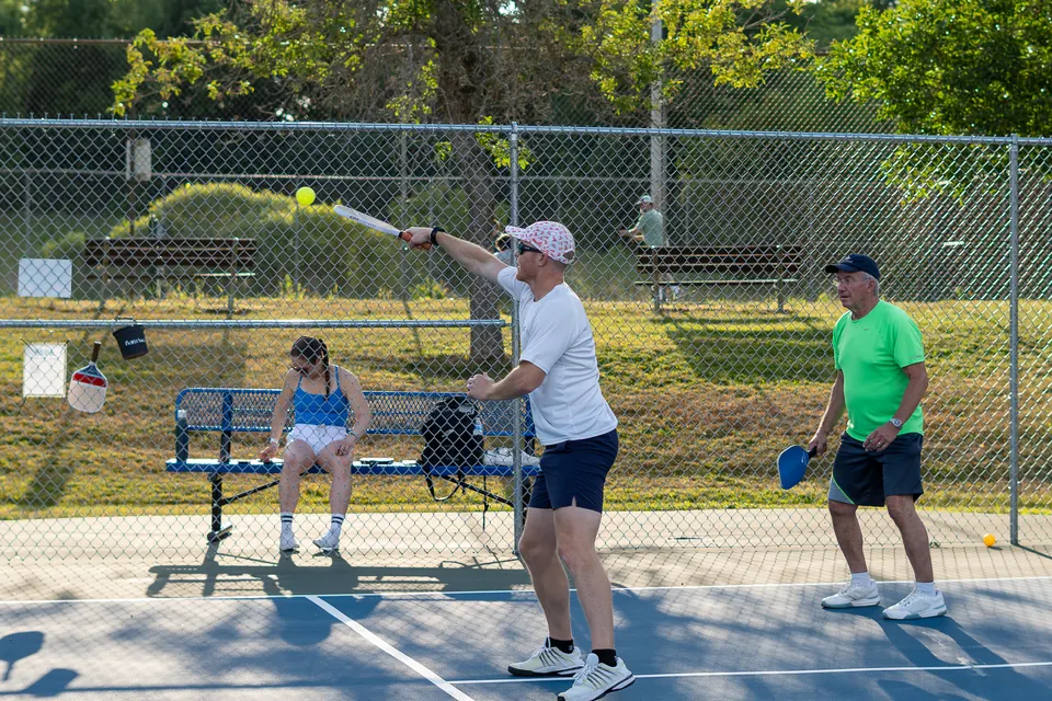 Pickleball doubles game on an outdoor court in Maine