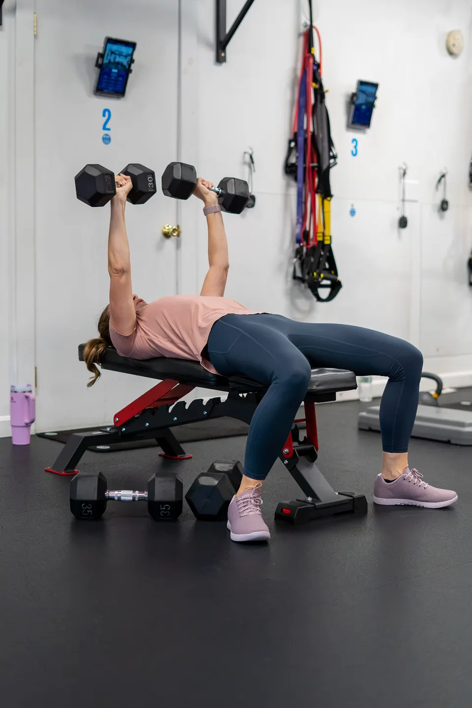 Member doing dumbbell presses on a bench
