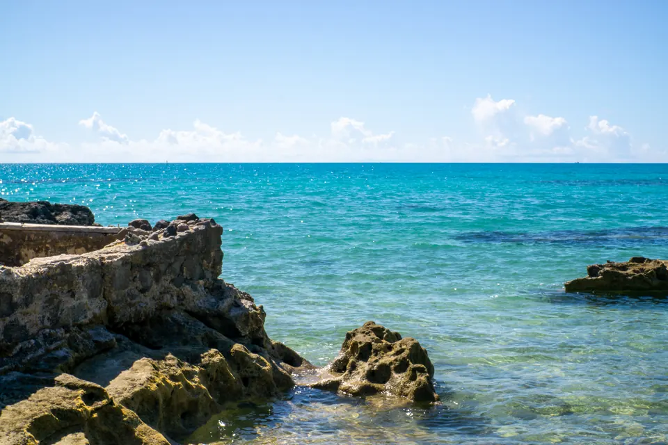 Turquoise water and dark rocks on a Bahamas shoreline