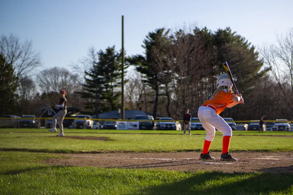 Batter in an orange jersey ready at the plate