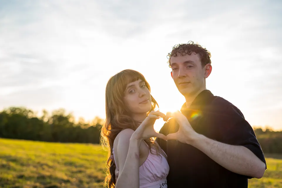 Couple framed by the setting sun in a Maine field