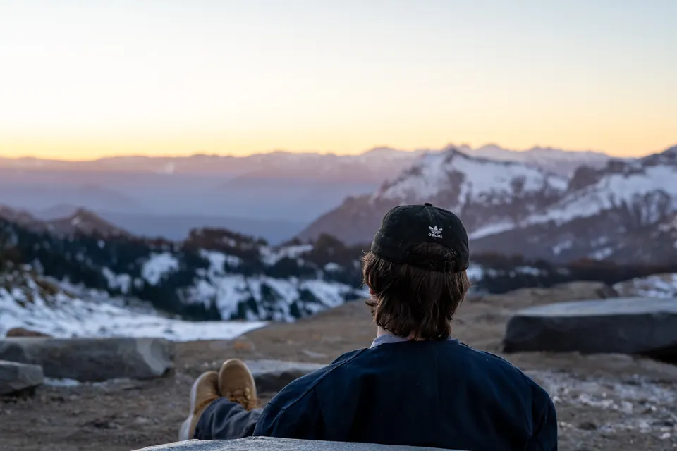 Hiker looking out over snowy Cascade ridges